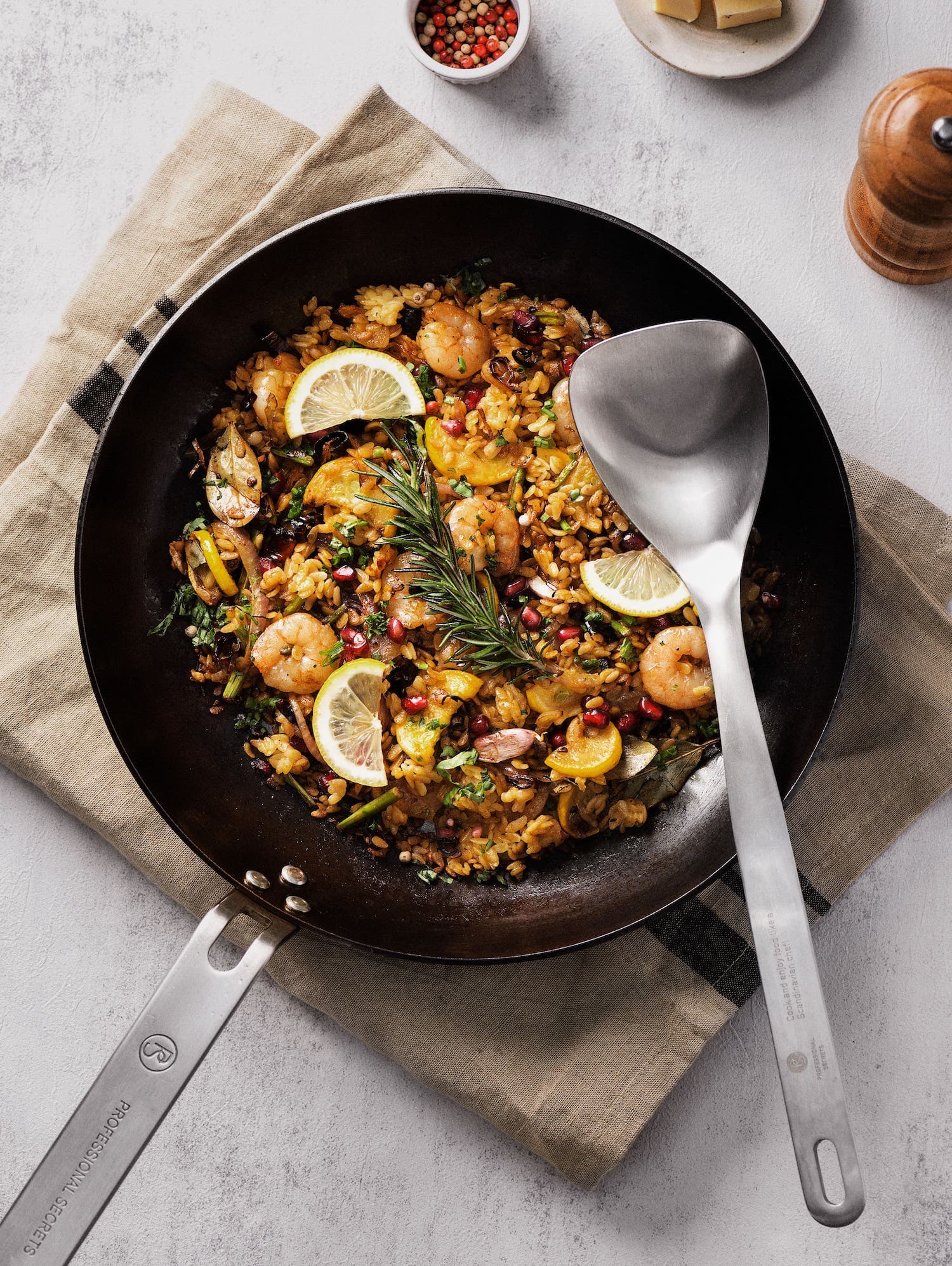 Paella i kolstålspanna med matlagningssked
