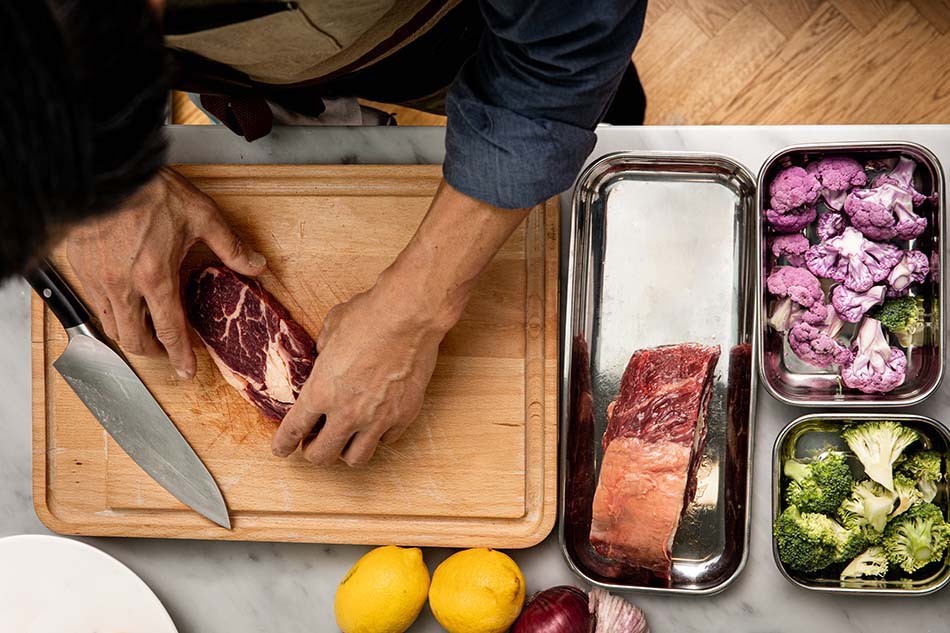 kött och grönsaker i mise en place och på skärbräda